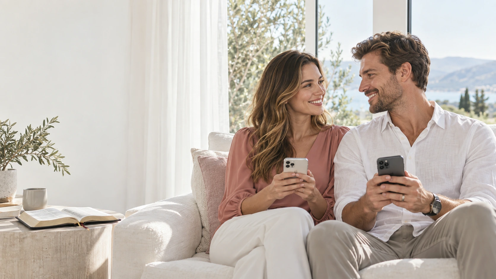 Casal sorrindo, cada um com seu celular, em um momento de fé na sala de casa